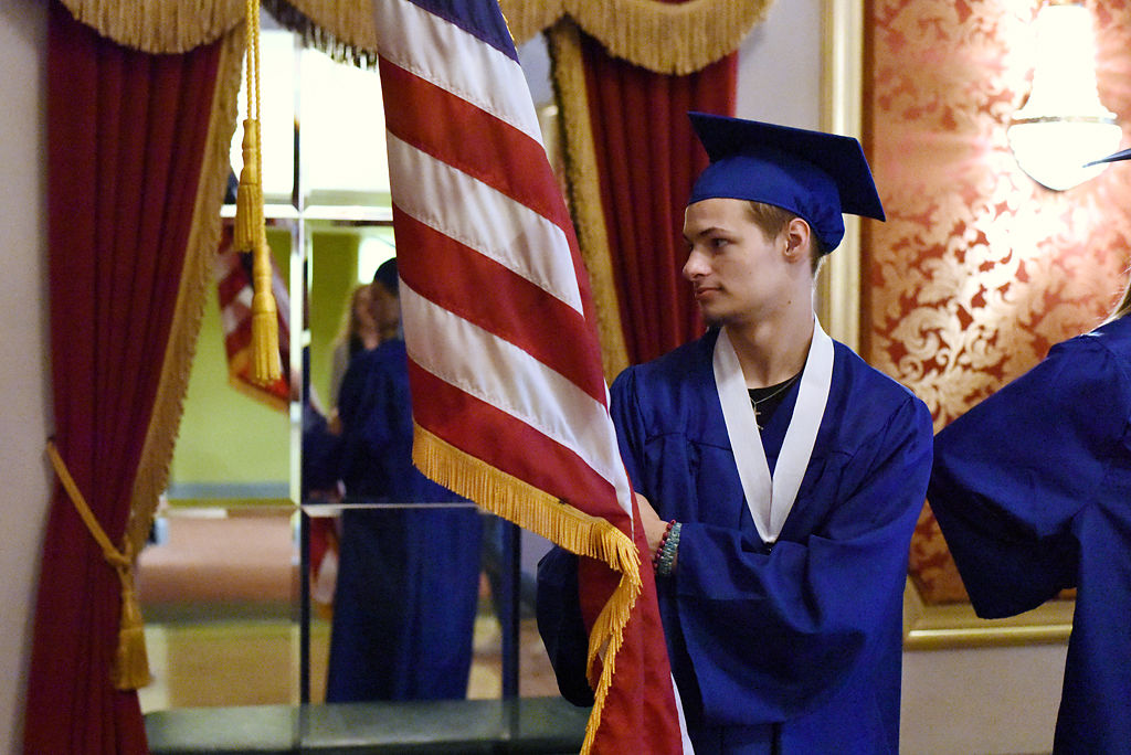 Flag bearer Dennis Peterson looks at the American flag